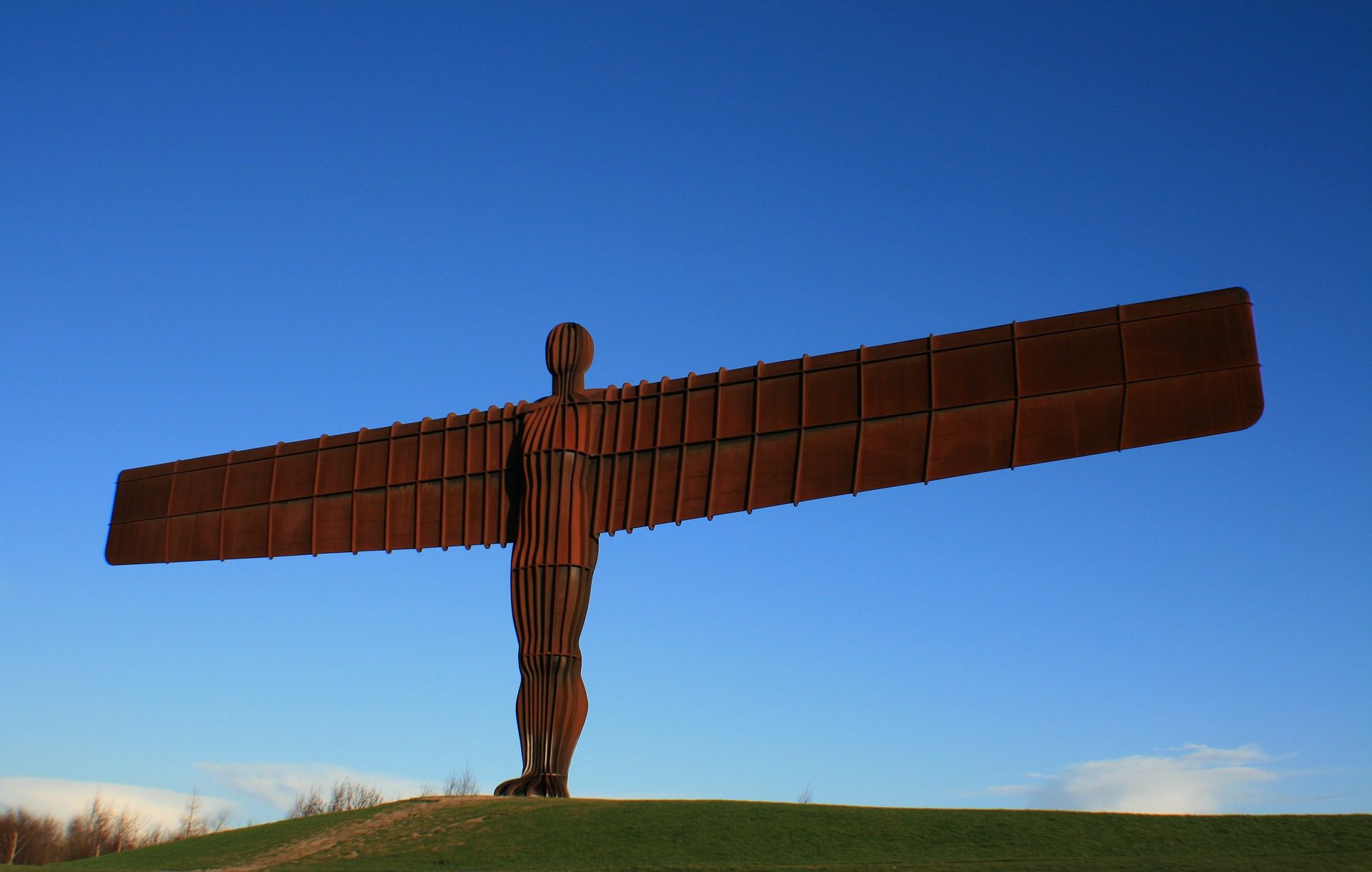The Angel of the North against a bright, blue sky
