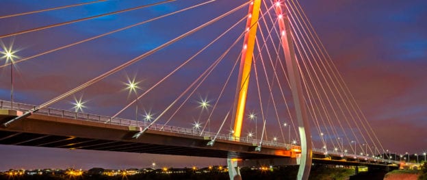 Photo of the Northern Spire Bridge illuminated at night