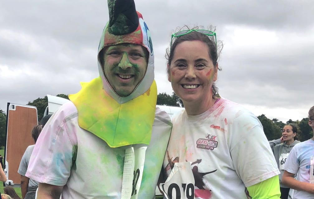 Photo of Chris and Lorna covered in coloured chalk after taking part in a colour run