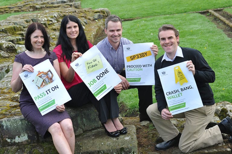 DTW staff holding a range of posters from the Law Society campaign