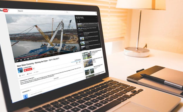 Photo of laptop showing YouTube video of erection of bridge