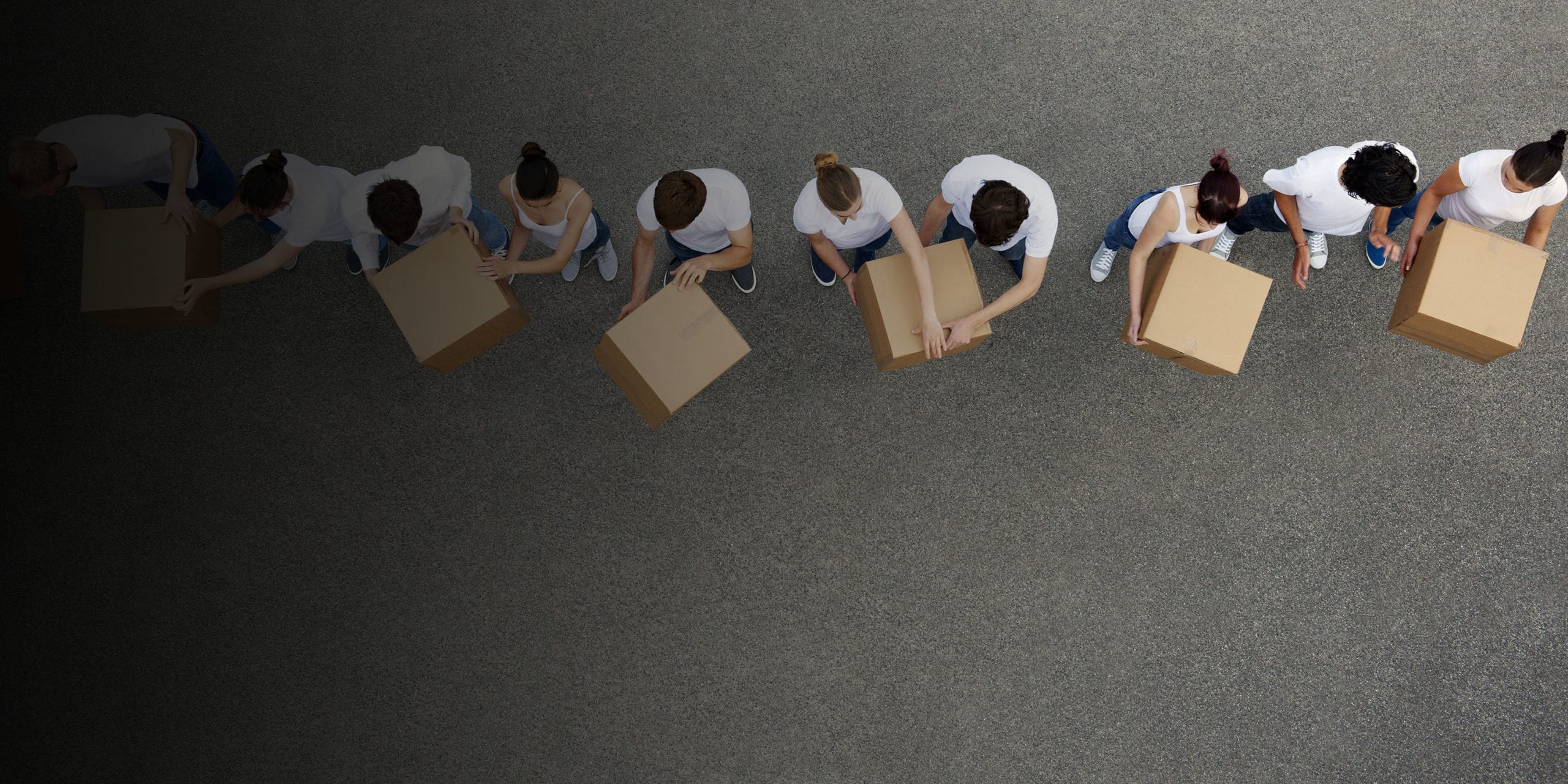 Overhead photo of people passing cardboard boxes along in a line