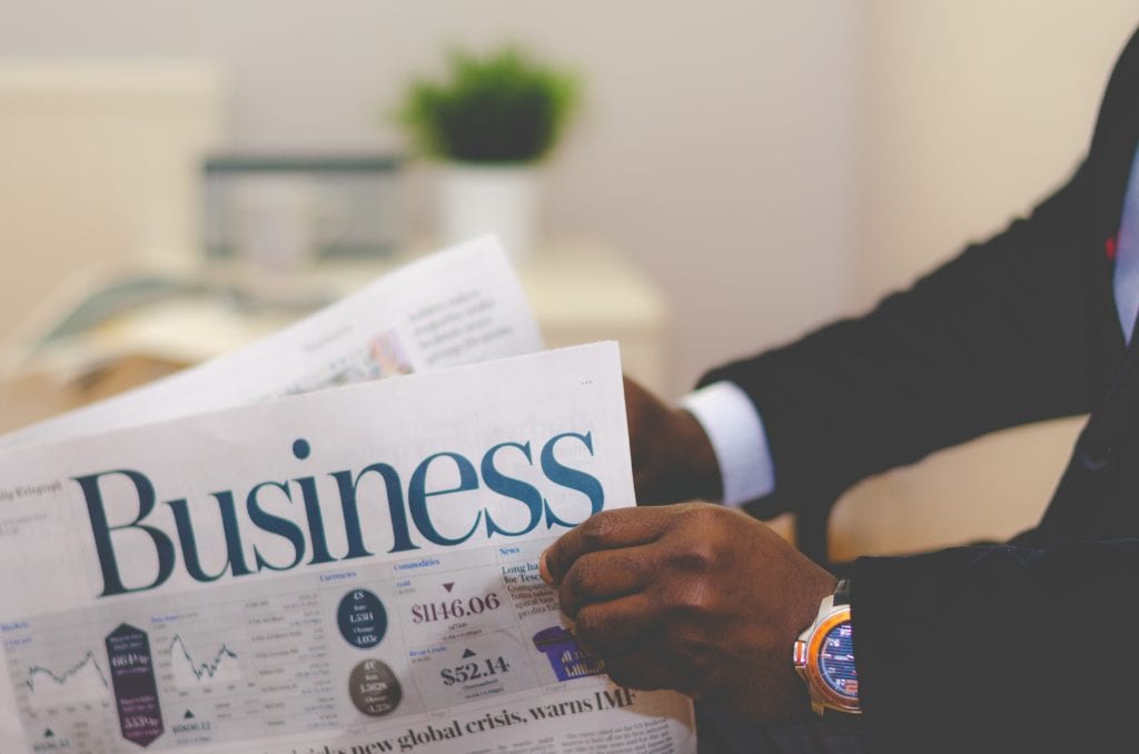 Photograph of person reading a business newspaper