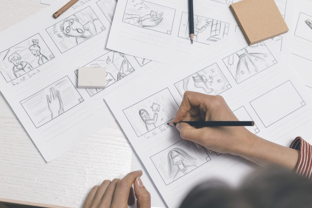 Photograph of a person drawing out a storyboard for an animation