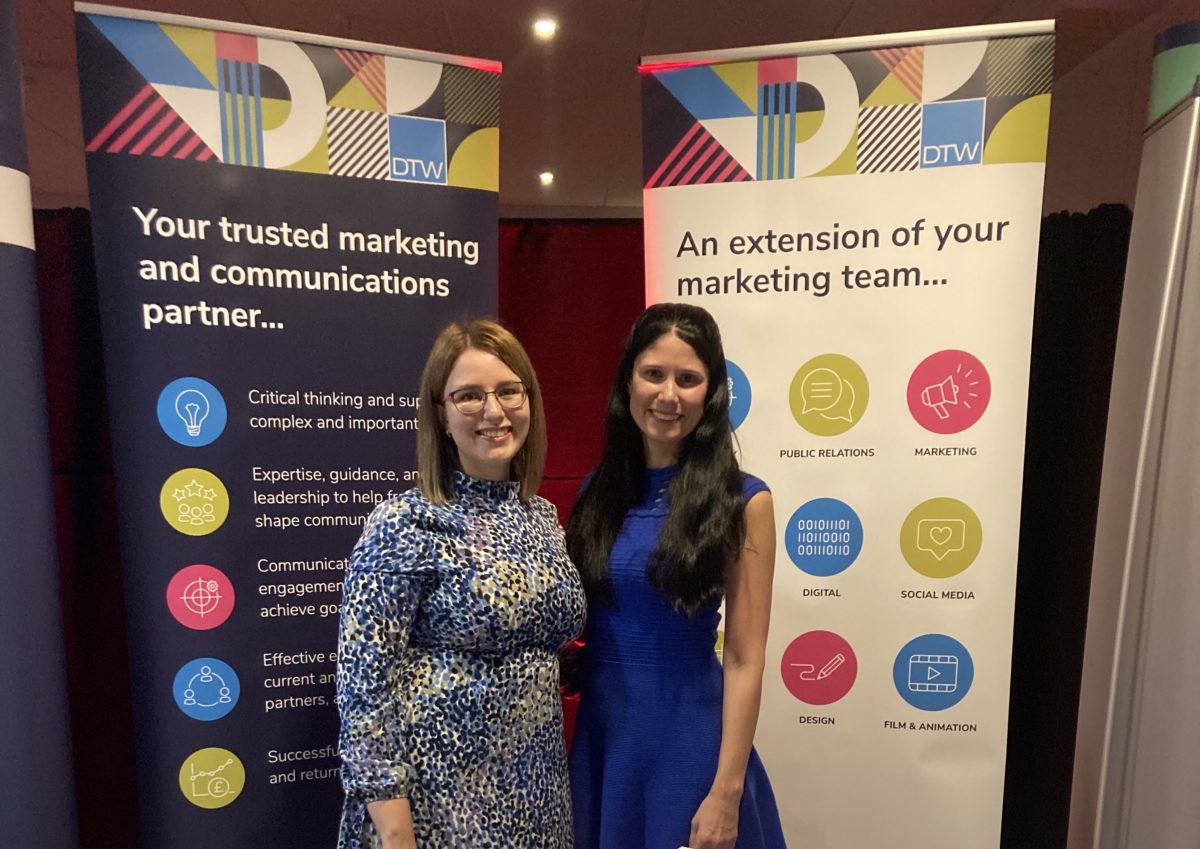 Hannah and Hayley in front of DTW's banner stands at the Memberwise conference 2022