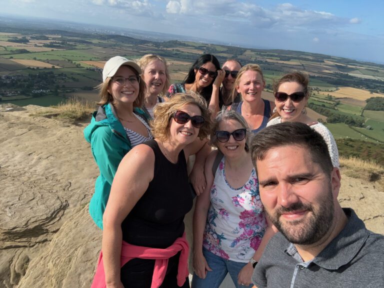 A selfie photograph of a group of intrepid DTW mountaineers at the summit of Roseberry Topping, a (small) mountain in North Yorkshire